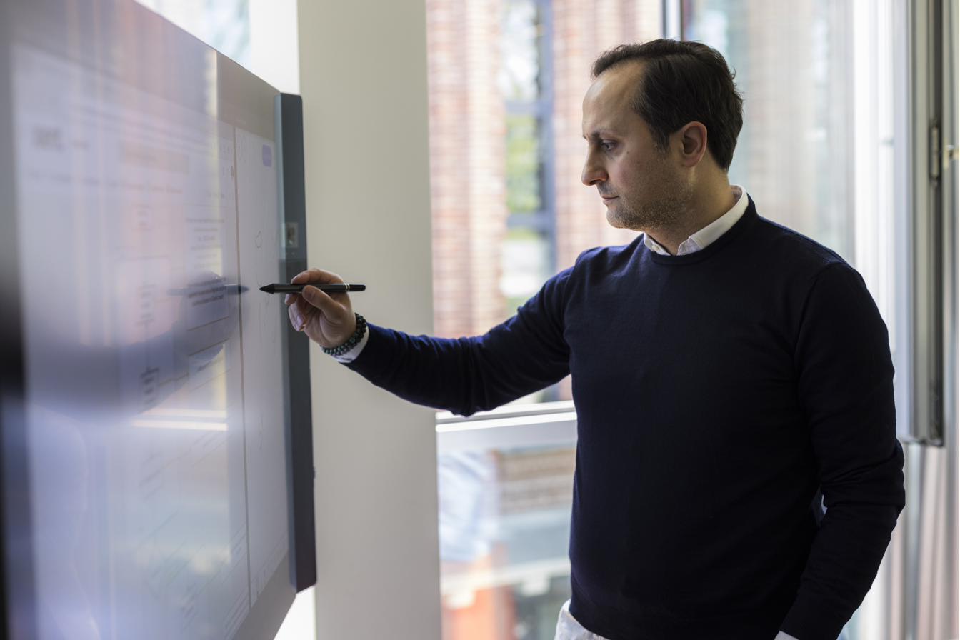 A Xient team member working at a digital whiteboard in the office