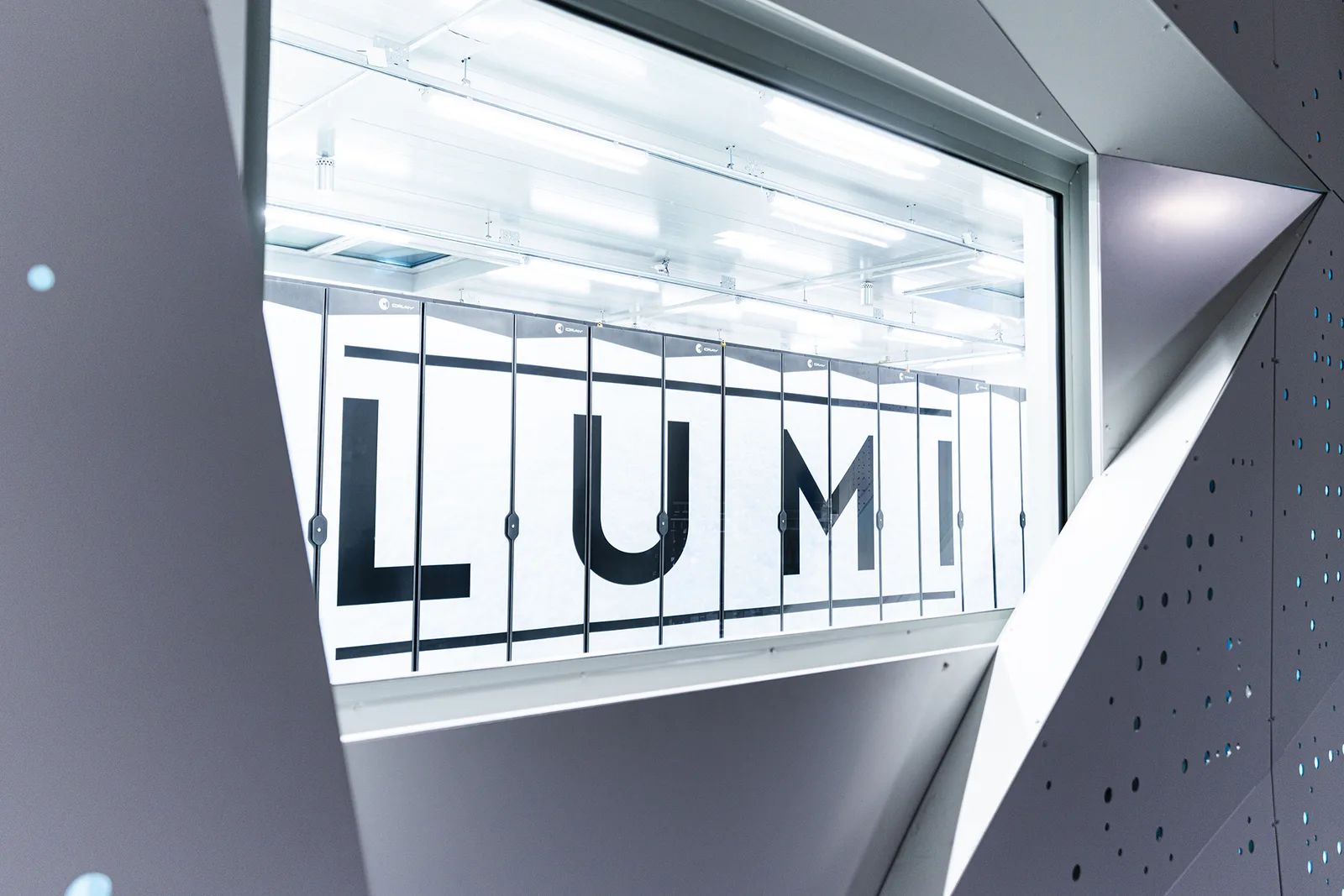 Blick durch ein Fenster auf die Rechnerschränke des LUMI-Supercomputers im CSC-Rechenzentrum in Kajaani, Finnland.