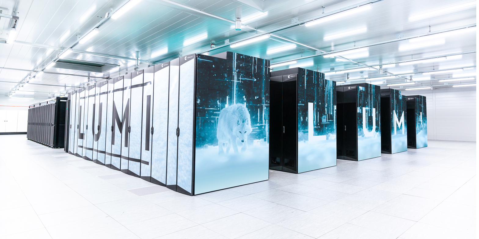 The LUMI supercomputer at the CSC data centre in Kajaani, Finland - rows of compute cabinets with LUMI branding.